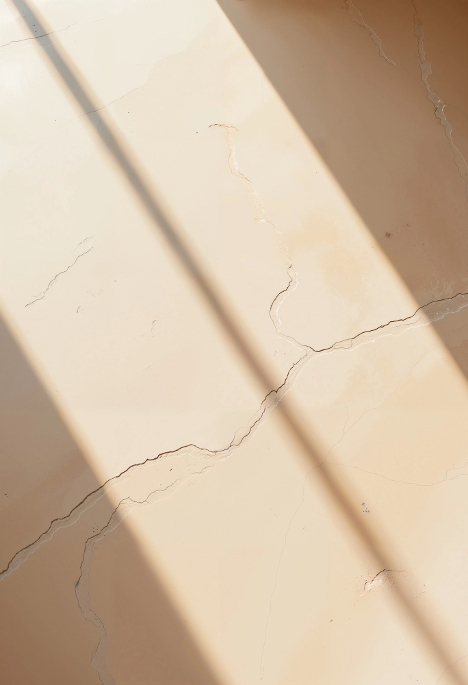 Foto de un muro con grietas y rayos de sol sobre él