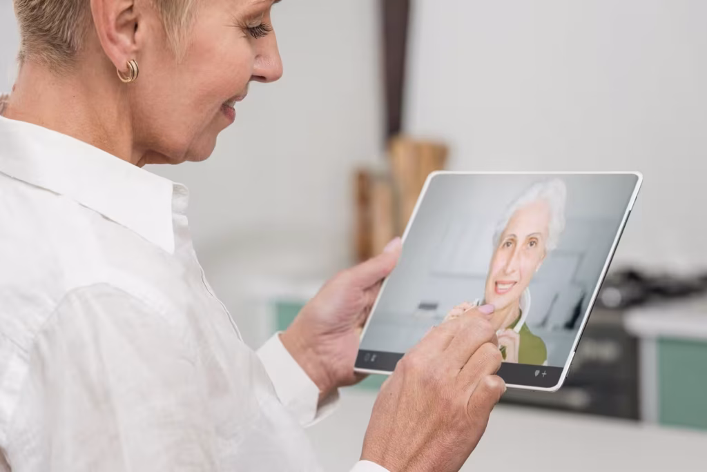 Mujer de edad mirando a otra personas en una tableta digital